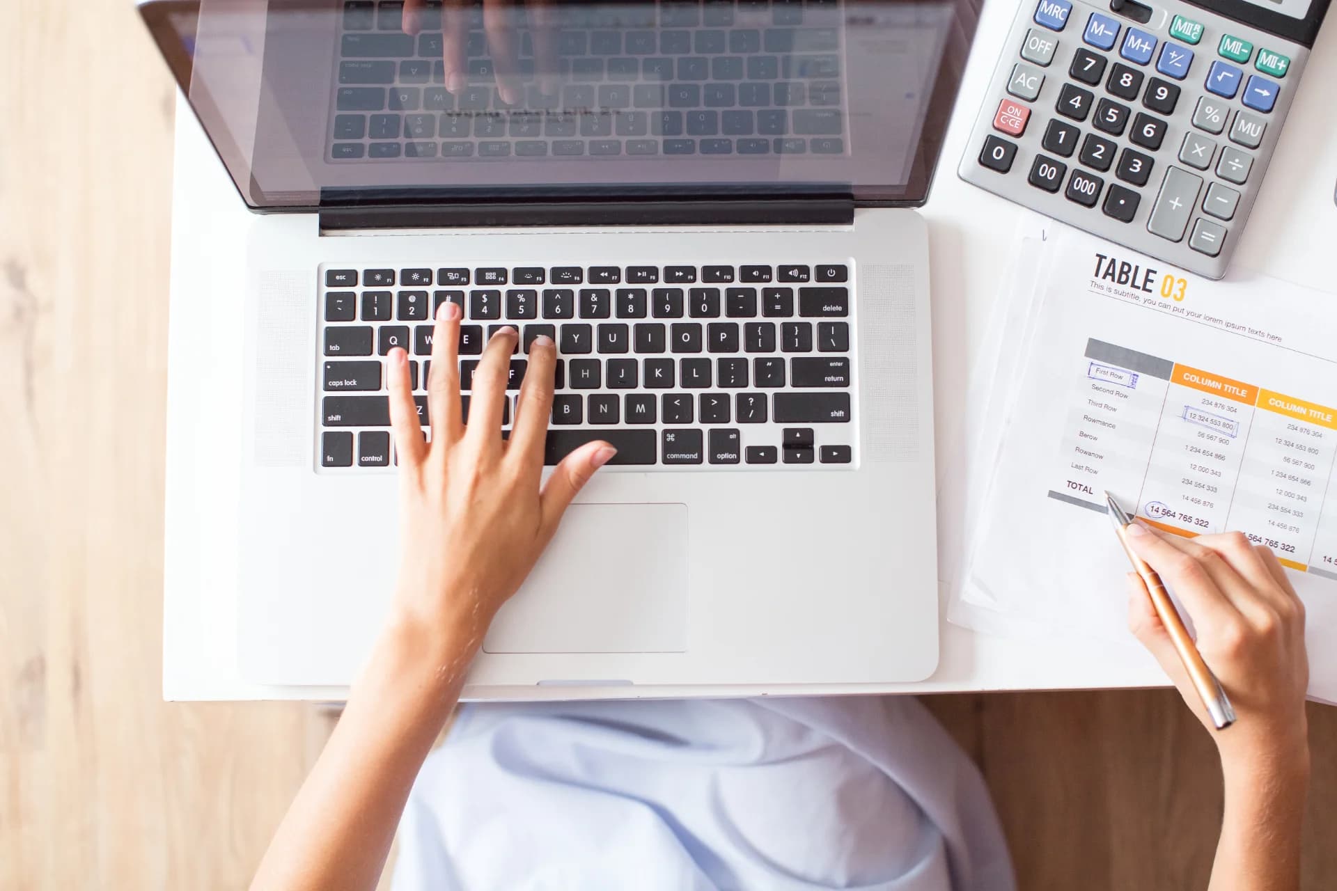 Accountant reconciling reports on a laptop with a calculator